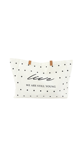 حقيبة كتف نسائية قماش بتصميم منقط باللون الأسود على خلفية بيضاء.