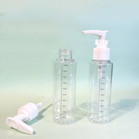 Set of clear 100ml pump bottles with white pump tops and visible front measurement lines.