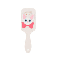 Off-white cat-themed square hair brush with pink bow; pin-studded pad and long handle