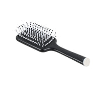 Black cushion hair comb with dense white pin teeth and a rounded handle