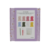 Purple crochet flower kit box back showing included yarn colors, tools, and book