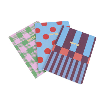 Notebook trio with red polka dot, green check, and blue striped covers, fanned