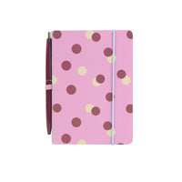 Pink polka-dot notebook with attached maroon pen, stationary kit