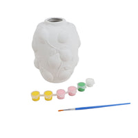 White blank ceramic vase with raised relief, paint pots, and blue paintbrush
