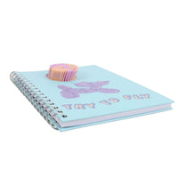 Light blue spiral notebook cover with purple balloon graphic and "TRY TO FLY" text