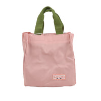 Pink handheld lunch bag with olive green handles and logo patch on front.