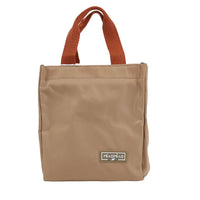 Beige handheld lunch bag with rust brown handles and logo patch on front.