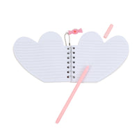 Open heart-shaped notebook with lined pages, pink pencil, and bow charm on chain