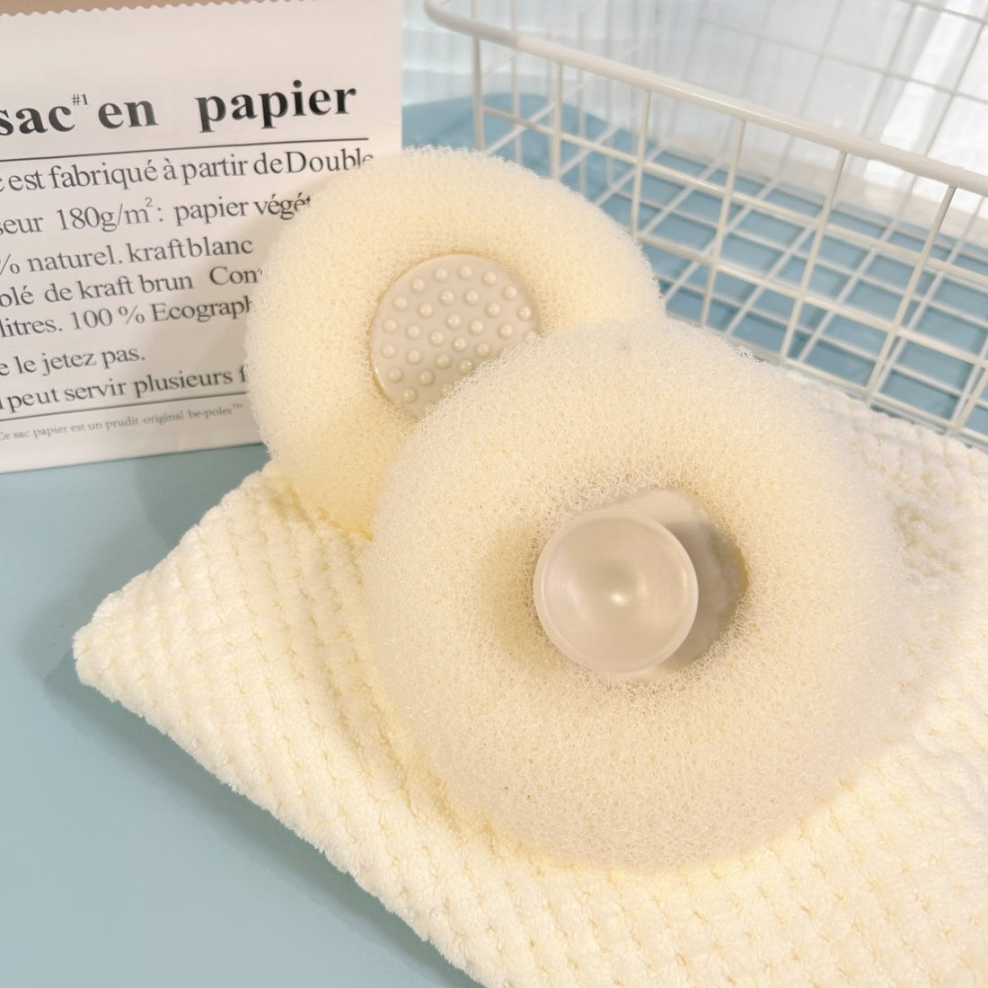 Cream cleaning sponge with textured surface and round soap holder.