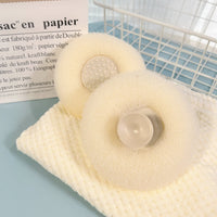 Cream cleaning sponge with textured surface and round soap holder.