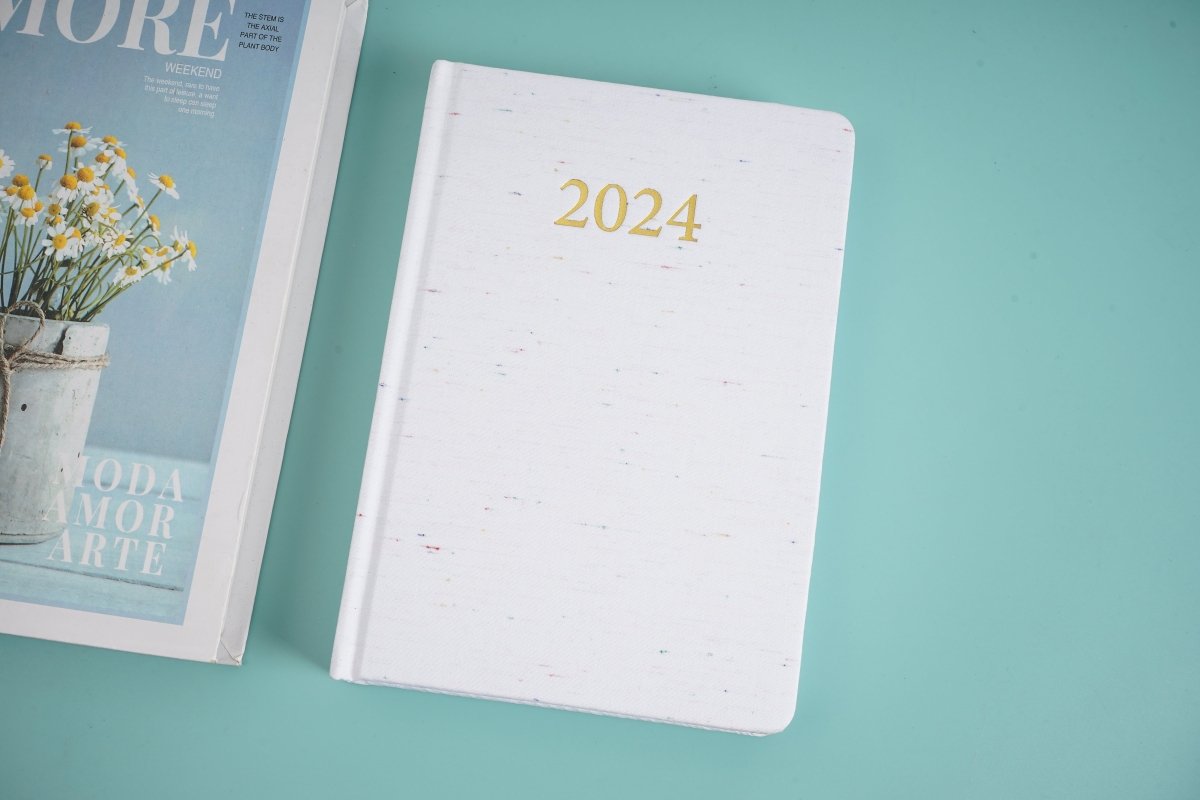 2024 daily planner, white front cover with gold '2024' on top