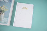 2024 daily planner, white front cover with gold '2024' on top