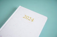 2024 daily planner, close-up of gold '2024' on white cover