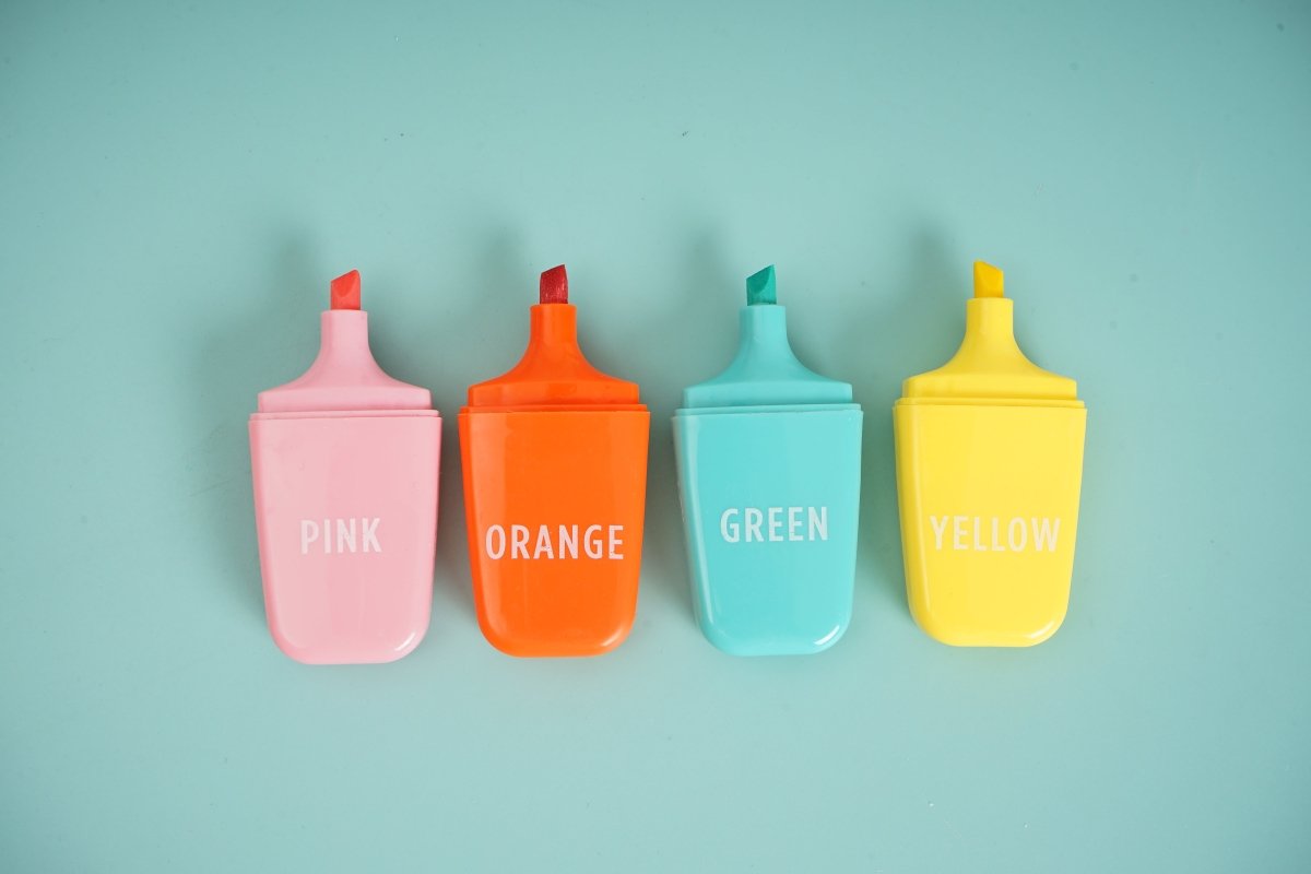 Four pastel highlighters: pink, orange, green, and yellow with caps