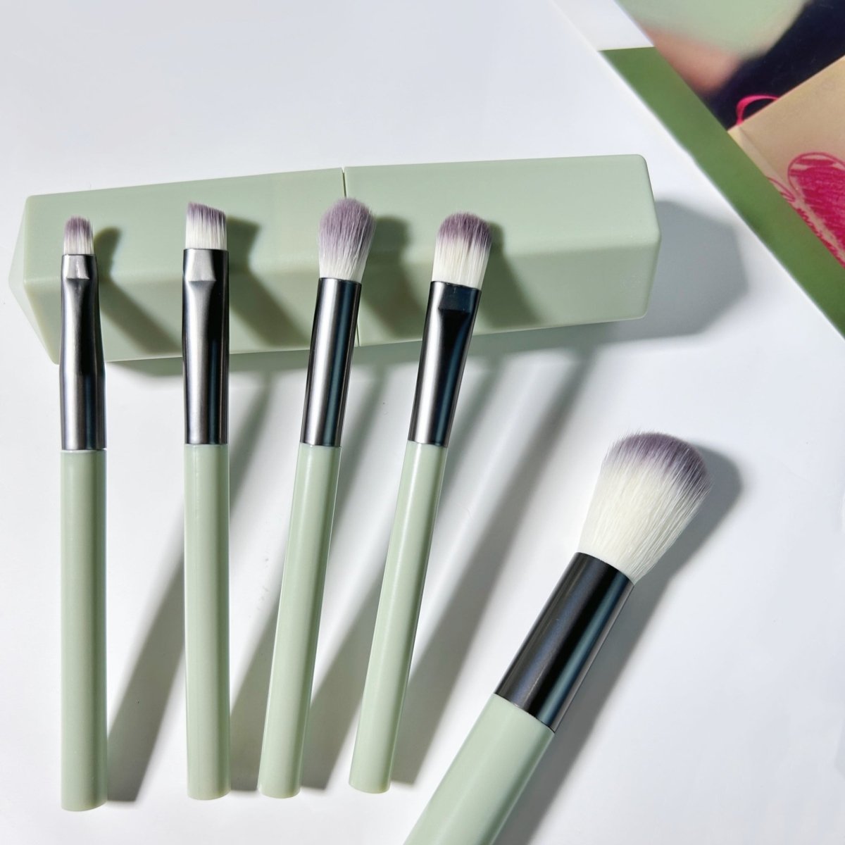Makeup brush set tray with five face brushes, mint handles, and silver ferrules
