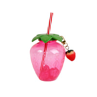 Pink strawberry drinking cup with green lid, red-white striped straw, and strawberry charm