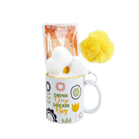 White ceramic mug gift set with plush flower, pom-pom stick, and matching notebook