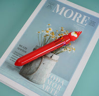 Red Santa Claus cap 6-color pen lying on side, showing multi-ink tips