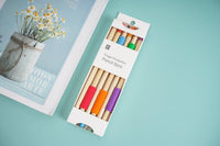 Six colored wooden pencils in a clear sleeve, showing colored barrels and sharpened tips