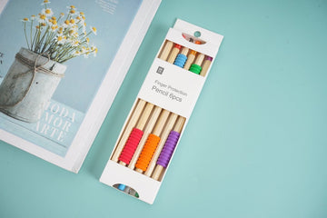 Six colored wooden pencils in a clear sleeve, showing colored barrels and sharpened tips