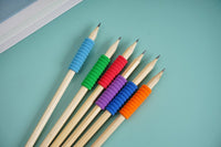 Six colored wooden pencils fanned out, with blue, green, red, purple and orange tips