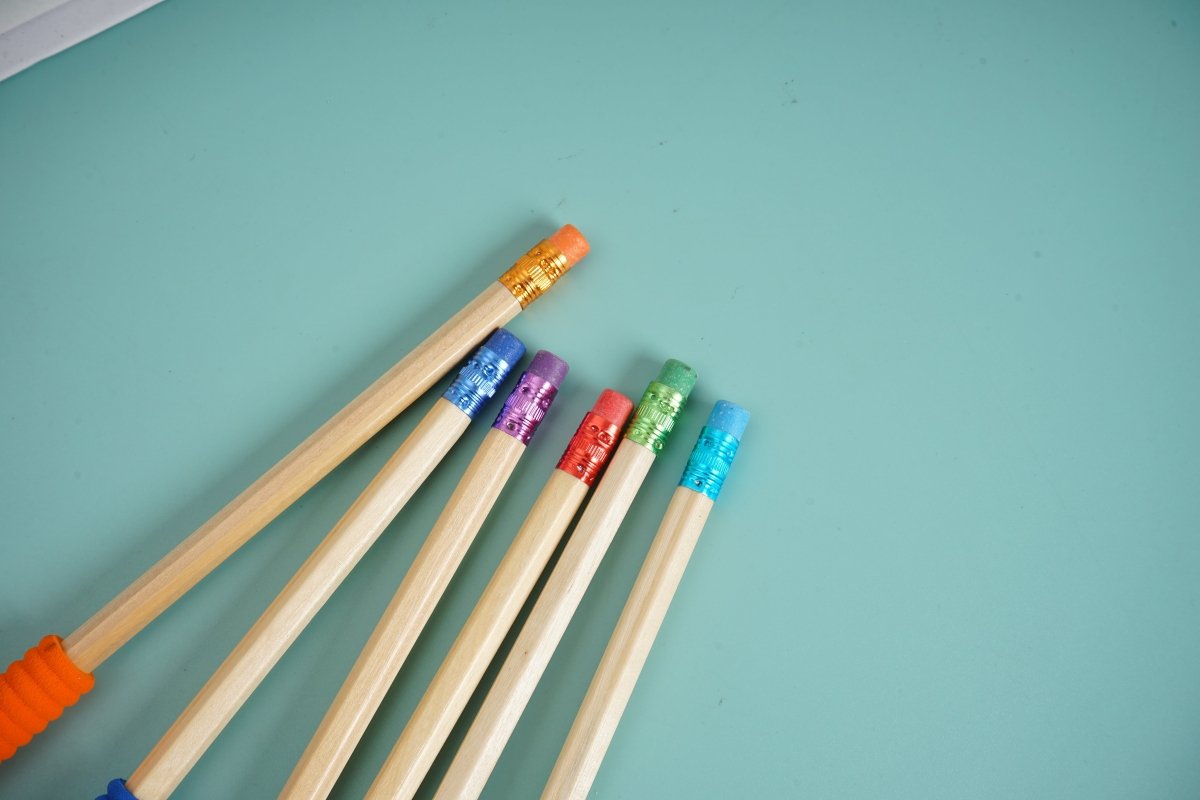 Colored wooden pencils with red, purple, teal and orange barrels, sharpened tips
