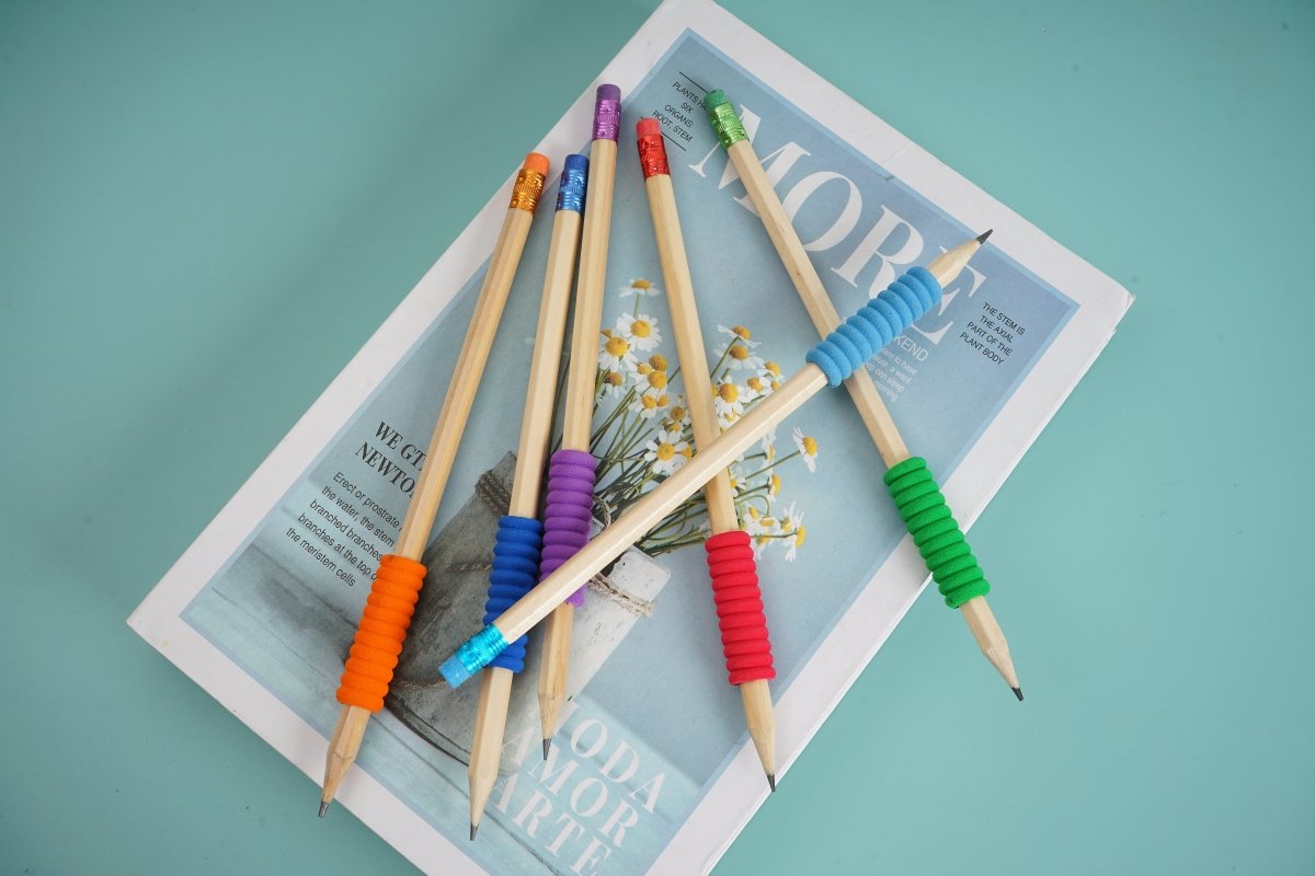 Colored wooden pencils on paper, showing sharpened tips and spiral erasers