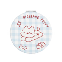 Round compact mirror with light blue plaid background and “Highland Puppy” text