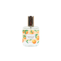 Eau de toilette spray bottle with gold cap and orange fruit leaf label