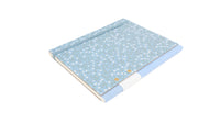 Printed hard surface notebook with blue patterned cover and white edge, angled view