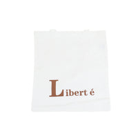 White canvas shoulder bag with brown 'Liberté' lettering