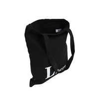 Black canvas shoulder bag with handle and 'Liberté' text