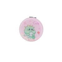 Round pink compact mirror with cute dinosaur illustration and glittery accents