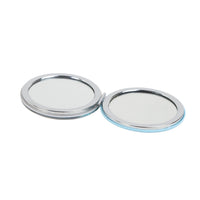 Round double-sided compact mirror with reflective surfaces, chrome edges and blue trim