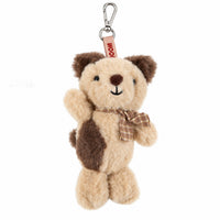 Plush dog keychain standing with metal hook, red fabric tag and brown plaid band