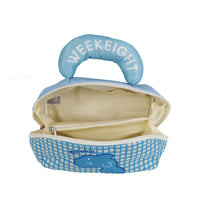 Opened blue plaid ocean makeup bag with curved handle and beige interior.