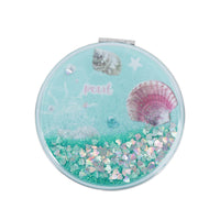 Mint round portable mirror with glitter, "pearl" text, and pink seashell graphics