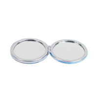 Open round portable compact mirror with two chrome-framed reflective discs
