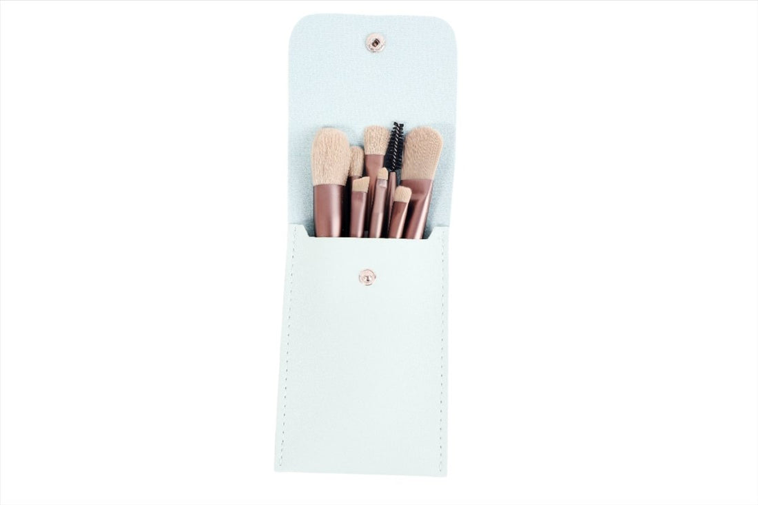 Mint pouch with 7 makeup brushes: soft beige bristles, rose-gold ferrules, white handles.