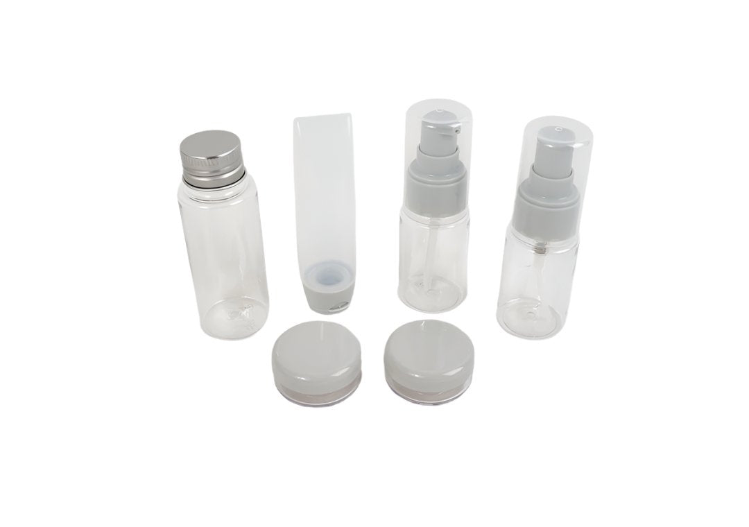 Travel empty bottle set with clear bottles, sprayer tops, and white containers