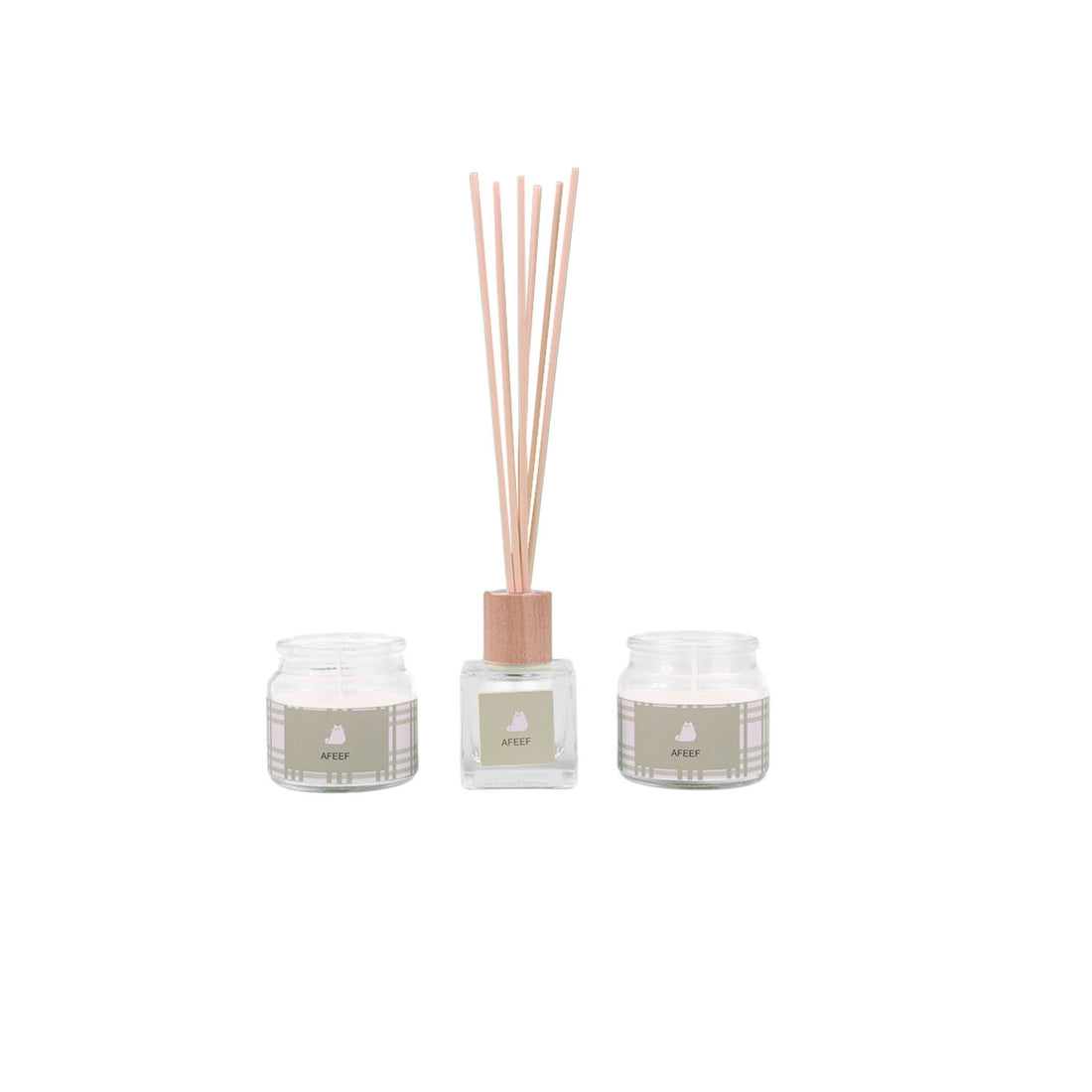 Reed diffuser and two scented candles in clear glass jars with pink reed sticks
