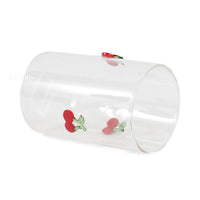 Clear glass tumbler with red cherry icons, angled view