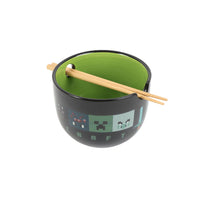 Black ramen bowl with green interior and pixel pattern, light wood chopsticks laid across