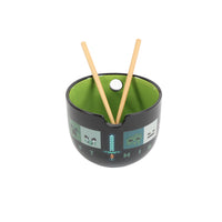 Black ramen bowl with green interior and pixel pattern, two light wood chopsticks inserted