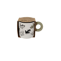 Ceramic cup with cute animal icons in a kraft box, cream handle visible