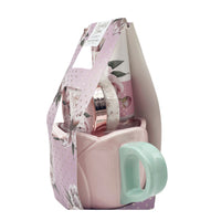 Gift bag with pink mug and mint handle, plus body care bottles in floral wrap.
