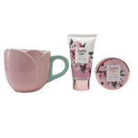 Gift set with pink mug, hand cream tube, and body scrub jar with peony artwork.