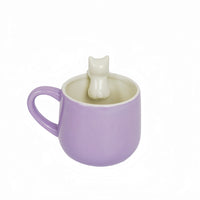 Purple ceramic mug with cat topper figurine and wide open cup.
