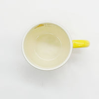 Cream cup with yellow handle; top interior view with smooth inner surface