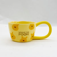 Yellow Winnie the Pooh long-handle coffee cup with centered bear and friends print